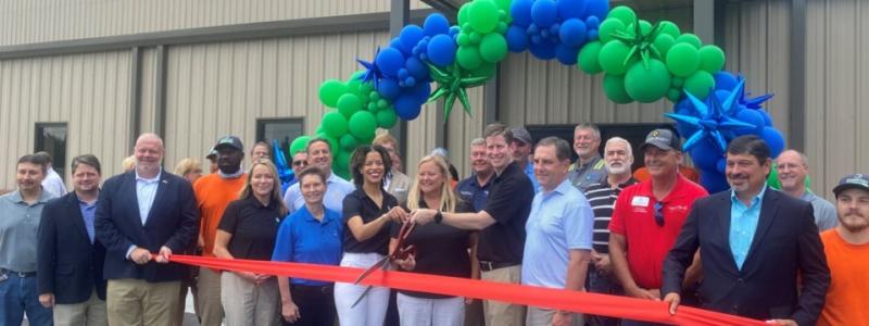 In the center of the photo, Vanécia Carr, EAM General Manager; Kim Sumner, EAM Director of Operations & Development; and Domtar Executive VP and Chief Operating Officer Steve Henry prepare to cut the ribbon on the EAM expansion. Photo: Domtar