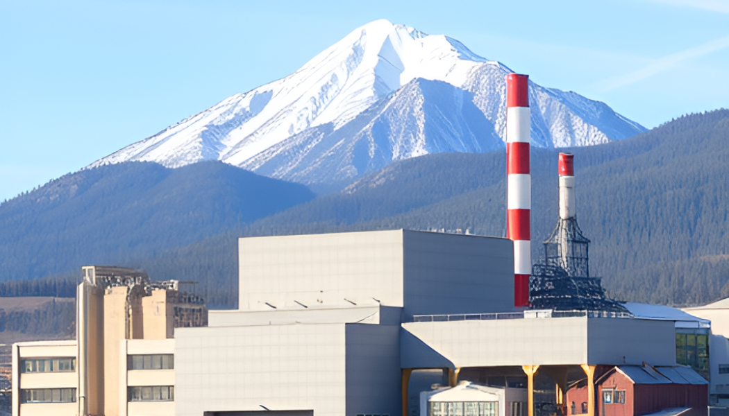 Modern pulp mill with mountain in the background.
