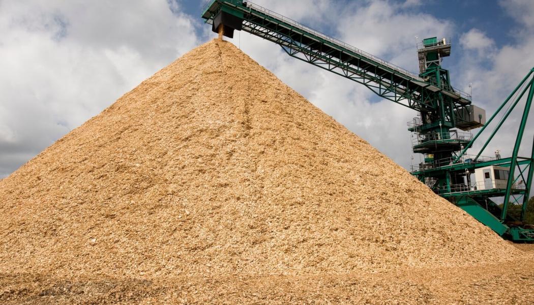 Photo of wood chips in Plymouth Mill woodyard, with chips exiting the chipper machine. Photo: Domtar 