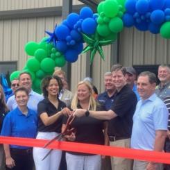 In the center of the photo, Vanécia Carr, EAM General Manager; Kim Sumner, EAM Director of Operations & Development; and Domtar Executive VP and Chief Operating Officer Steve Henry prepare to cut the ribbon on the EAM expansion. Photo: Domtar